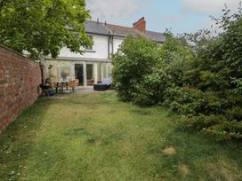 A garden with a table and chairs at The Hideaway in Penrhyn Bay