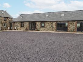 An outdoor view of a stone house with windows at 2 Trem Y Mor Llanfwrog near Llanfachraeth