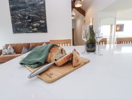 A kitchen with bread and champagne on a table at 2 Trem Y Mor Llanfwrog near Llanfachraeth