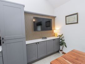 A living room with a television and a lamp at 2 Trem Y Mor Llanfwrog near Llanfachraeth