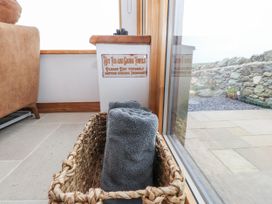 A basket with towels and a sign near a window at 2 Trem Y Mor Llanfwrog near Llanfachraeth