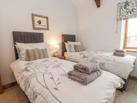 A bedroom with two beds and a lamp at 2 Trem Y Mor Llanfwrog near Llanfachraeth