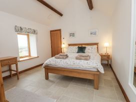 A bedroom with a bed and bedside table at 2 Trem Y Mor in Llanfwrog near Llanfachraeth
