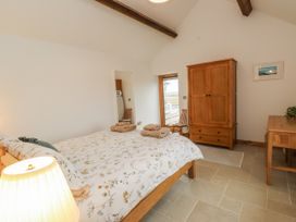A bedroom with a bed and wardrobe at 2 Trem Y Mor Llanfwrog near Llanfachraeth