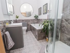 A bathroom with a sink, bathtub, shower, and toilet at 2 Trem Y Mor Llanfwrog near Llanfachraeth