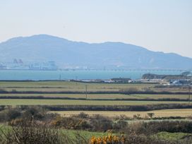 A view of a ferry in the sea with mountains in the background at 2 Trem Y Mor Llanfwrog near Llanfachraeth