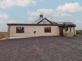 A wooden house with windows and gravel area at Hen Penmynydd Llanfwrog near Llanfachraeth