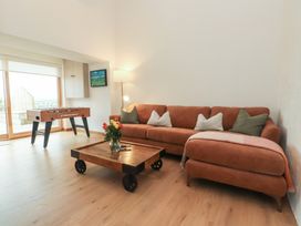A living room with a sofa and foosball table at Hen Penmynydd near Llanfwrog Llanfachraeth