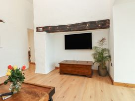 A living room with a television and a coffee table at Hen Penmynydd in Llanfwrog near Llanfachraeth