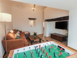 A living room with a foosball table and a sofa at Hen Penmynydd in Llanfwrog near Llanfachraeth