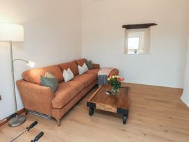 A living room with a sofa and coffee table at Hen Penmynydd Llanfwrog near Llanfachraeth