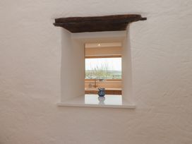 A kitchen view with a window and a blue decorative vase at Hen Penmynydd Llanfwrog near Llanfachraeth