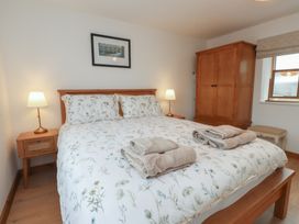 A bedroom with a bed and wardrobe at Hen Penmynydd in Llanfwrog near Llanfachraeth