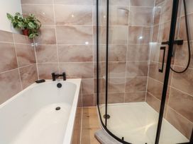 A bathroom with a bathtub and a shower at Hen Penmynydd near Llanfwrog Llanfachraeth