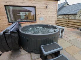 A hot tub on a slate patio at Hen Penmynydd in Llanfwrog near Llanfachraeth