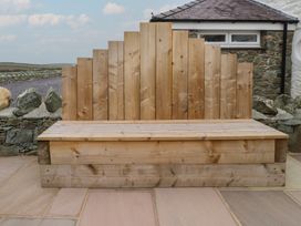 A wooden bench against a stone wall at Hen Penmynydd Llanfwrog near Llanfachraeth