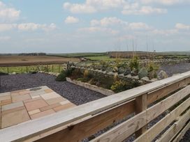 An outdoor area with a stone wall and gravel at Hen Penmynydd in Llanfwrog near Llanfachraeth