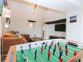 A living room with a foosball table and a sofa at Hen Penmynydd in Llanfwrog near Llanfachraeth