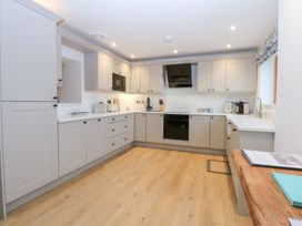 A kitchen with cabinets and appliances at Hen Penmynydd in Llanfwrog near Llanfachraeth