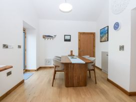 A dining room with a table and chairs at Hen Penmynydd in Llanfwrog near Llanfachraeth