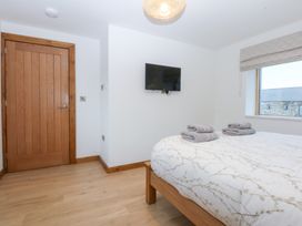 A bedroom with a bed and television at Hen Penmynydd Llanfwrog near Llanfachraeth