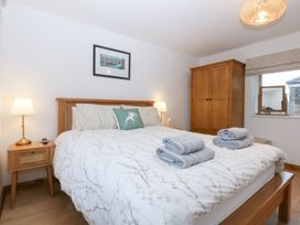 A bedroom with a bed, wardrobe, and bedside table at Hen Penmynydd in Llanfwrog near Llanfachraeth