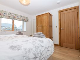A bedroom with two beds and a wardrobe at Hen Penmynydd Llanfwrog near Llanfachraeth