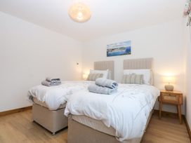A bedroom with two beds and a nightstand at Hen Penmynydd in Llanfwrog near Llanfachraeth
