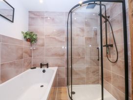 A bathroom with a bathtub and shower at Hen Penmynydd near Llanfwrog Llanfachraeth