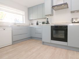 A kitchen with cabinets, sink, oven, and dishwasher at Shearwater, Praa Sands