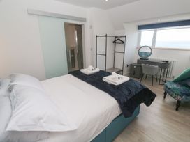 A bedroom with a bed and desk at Shearwater in Praa Sands