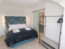 A bedroom with a bed and clothing rack at Shearwater in Praa Sands