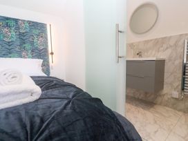A bedroom with a bed and bathroom area at Shearwater in Praa Sands