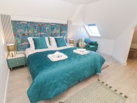A bedroom with a bed, bedside table, and a couch at Shearwater in Praa Sands
