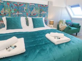 A bedroom with a bed and seating area at Shearwater in Praa Sands