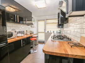 A kitchen with a stove and microwave at Esplanade Gardens, Apartment 1 in Scarborough