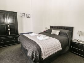 A bedroom with a bed and a wardrobe at Esplanade Gardens, Apartment 1 in Scarborough