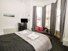 A bedroom with a bed and television at Esplanade Gardens, Apartment 1 in Scarborough