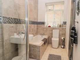 A bathroom with a shower, bathtub, toilet, and sink at Esplanade Gardens, Apartment 1 in Scarborough