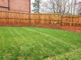 A garden area with grass and wooden fence at 49 Mellings Place