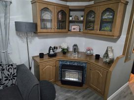 A living room with a cabinet and lamp at Caravan number 85