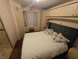 A bedroom with a bed and window at Caravan number 85 