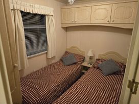 A bedroom with two single beds and a bedside table at Caravan number 85
