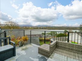 A balcony with rattan furniture overlooking a river at 4 Brynteg Terrace Menai Bridge