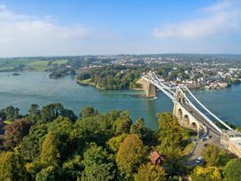 An aerial view of a bridge over a river with trees and buildings at 4 Brynteg Terrace Menai Bridge