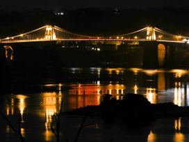 A bridge lit at night over a river at 4 Brynteg Terrace in Menai Bridge