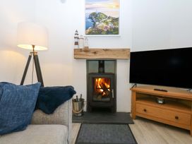 A living room with a fireplace and television at 4 Brynteg Terrace Menai Bridge