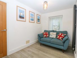 A snug with a sofa and framed posters at 4 Brynteg Terrace Menai Bridge