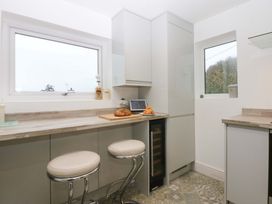 A kitchen with countertop, barstools, and a tablet at 4 Brynteg Terrace in Menai Bridge