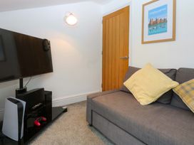 A living room with a television and sofa at 4 Brynteg Terrace Menai Bridge